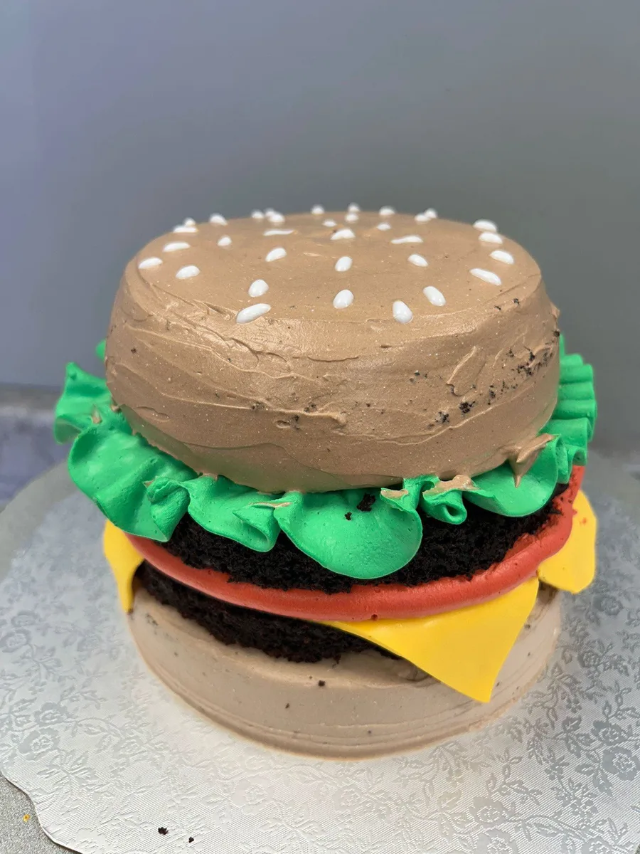 Cake decorated to look like a cheeseburger with buttercream lettuce