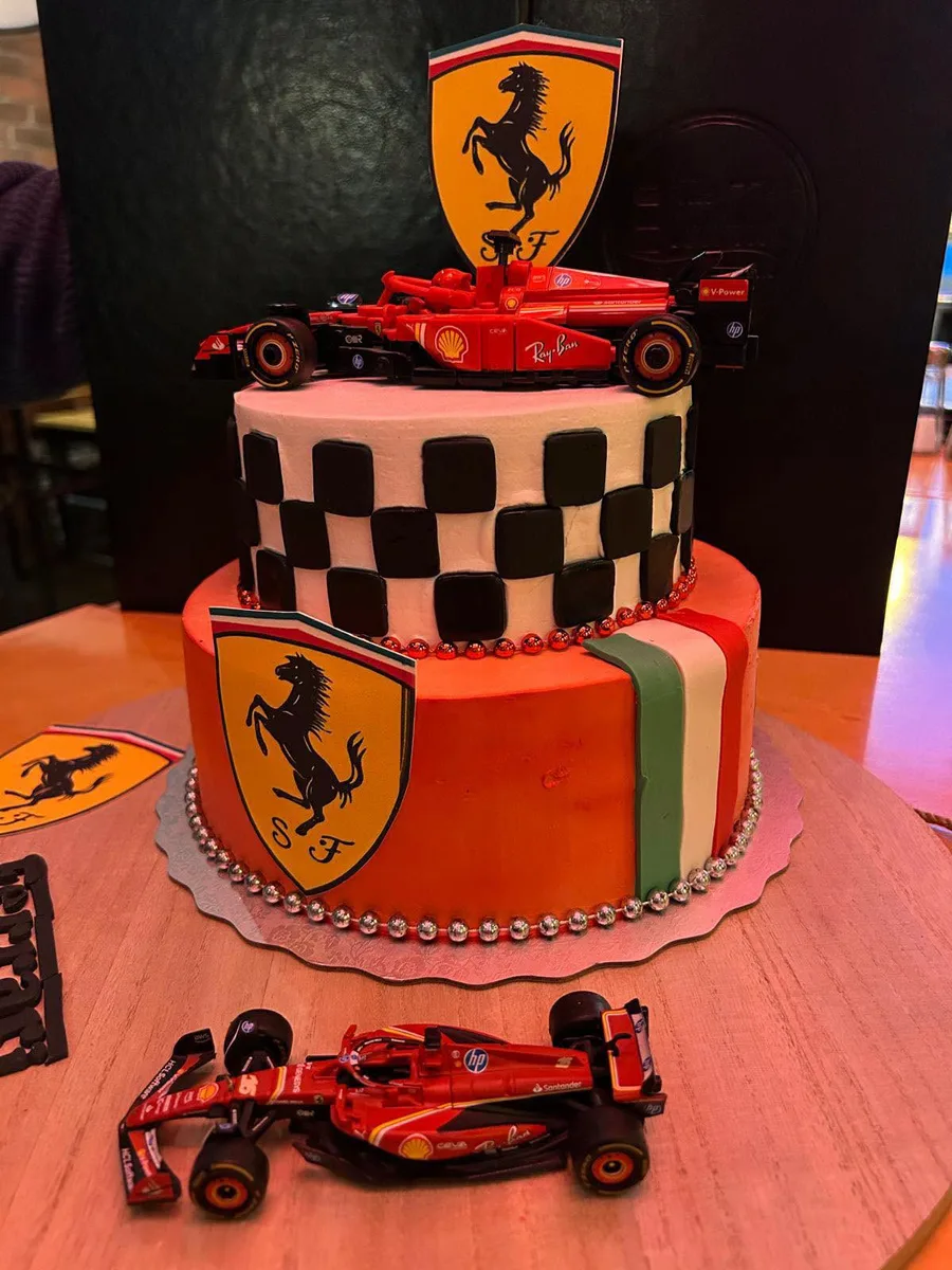 Two tier Ferrari racing cake with checkered flag tier and model F1 cars