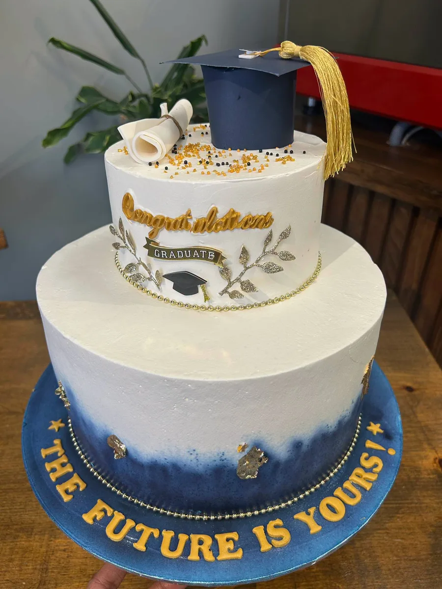 Two tier graduation cake with navy ombre base reading The Future Is Yours