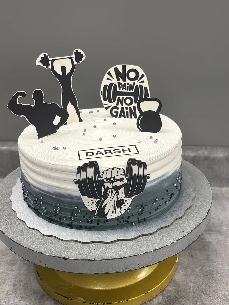 Gym themed birthday cake with barbell and kettlebell toppers