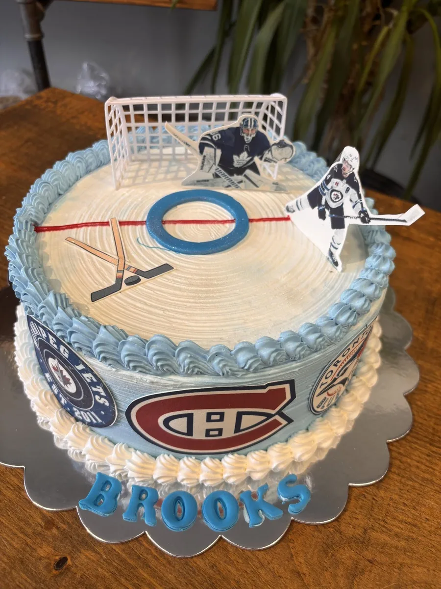 Hockey rink birthday cake with net, players and team logos